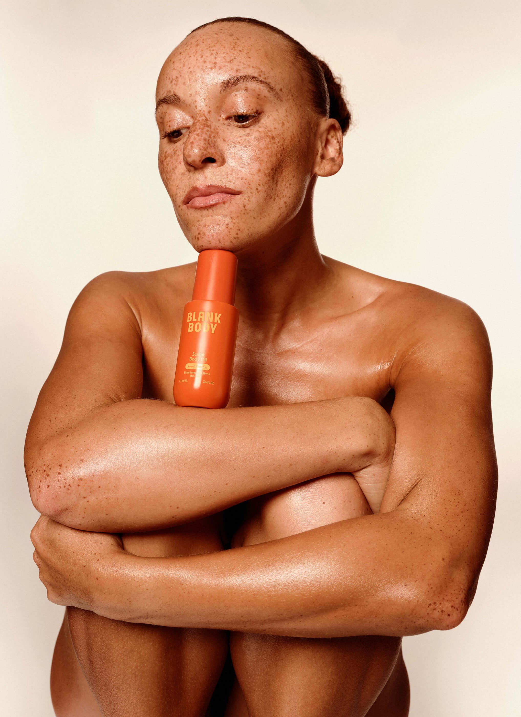 Une photographie de campagne reprend le flacon et la palette chaude de la marque.