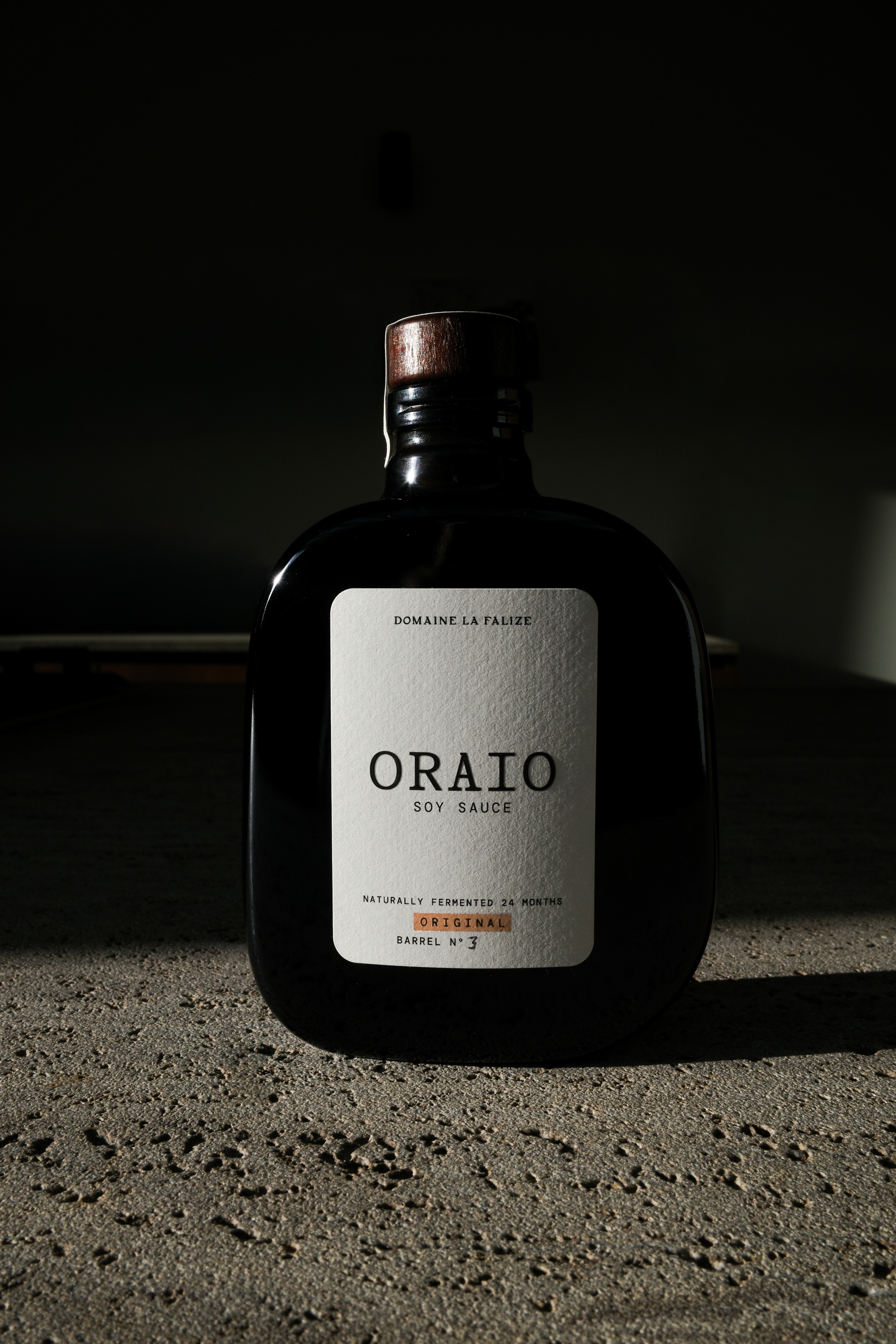 Le flacon Oraio est mis en scène dans une lumière sombre.